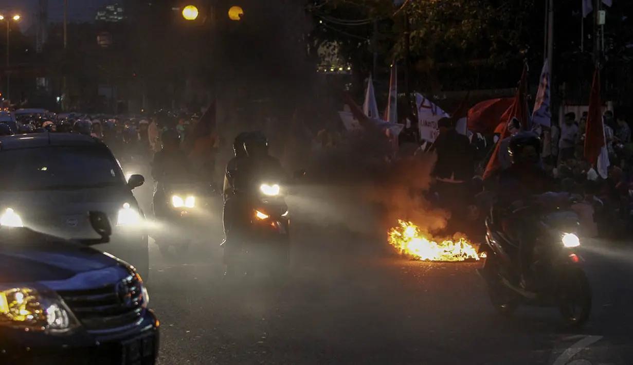 Mahasiswa menutup Jalan Diponegoro, Jakarta dan melakukan aksi bakar ban, Rabu (3/12/2014). (Liputan6.com/Faizal Fanani)