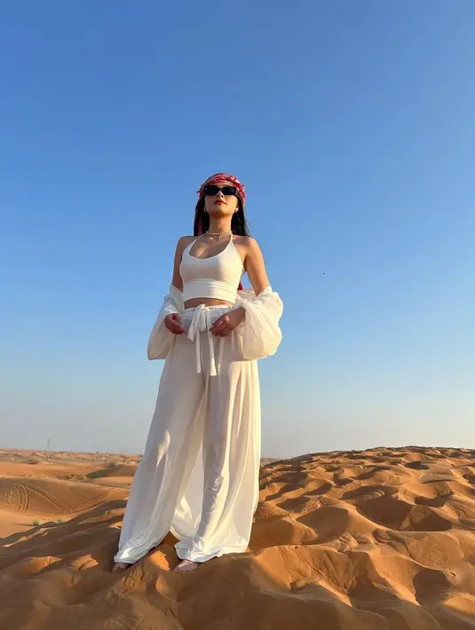 Caitlin Halderman tampil bak musafir dengan busana all white loose minimalis dan sorban merah [@caitlinhalderman]