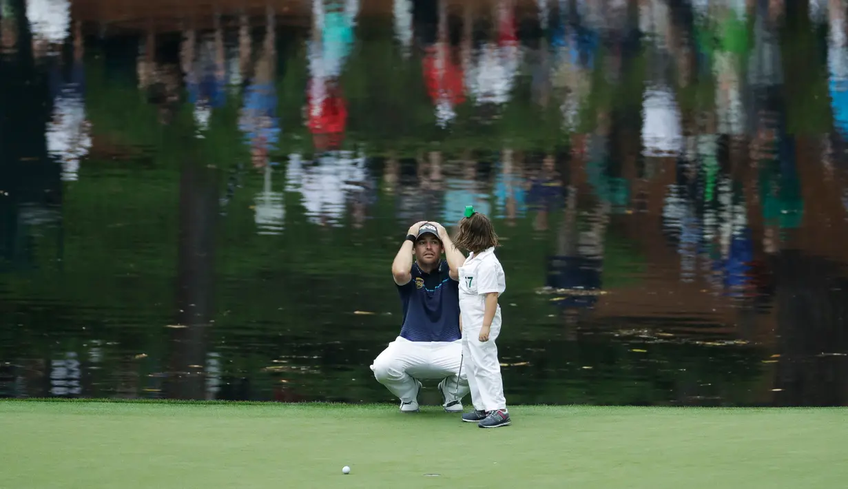Pegolf Louis Oosthuizen dari Afrika Selatan berbincang dengan putrinya Jana putts saat mengikuti acara Masters Par 3 Tournament di Augusta National Golf Club, Georgia, (5/4). (AP Photo / Matt Slocum)