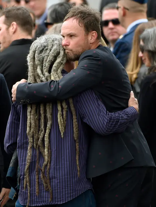 Jeff Ament, dari Pearl Jam, memeluk seorang tamu di sebuah pemakaman untuk Chris Cornell di Hollywood Forever Cemetery di Los Angeles, AS (26/5). (Photo by Chris Pizzello/Invision/AP)