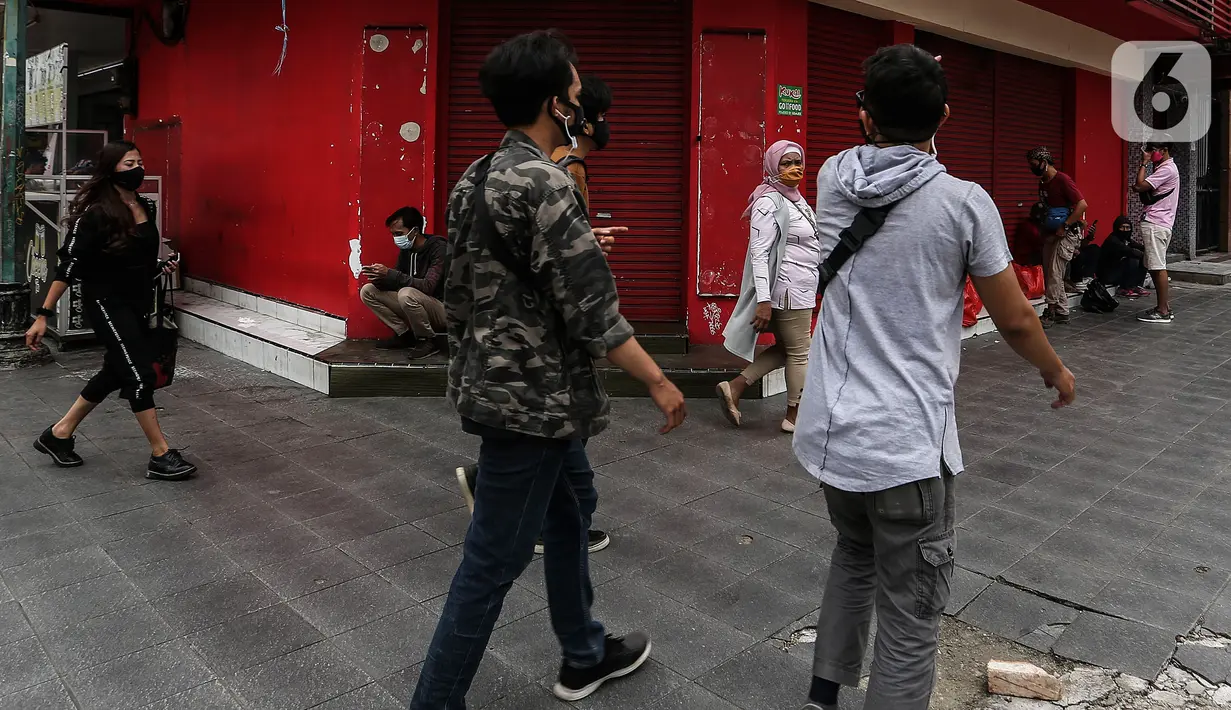 Sejumlah orang melintas di kawasan Blok M, Jakarta, Minggu (17/1/2021). Per data hari ini, Minggu (17/1), ada tambahan 11.287 orang terkonfirmasi Corona Covid-19. Sehingga total menjadi 907.929 kasus positif corona Covid-19 di Indonesia. (Liputan6.com/Johan Tallo)