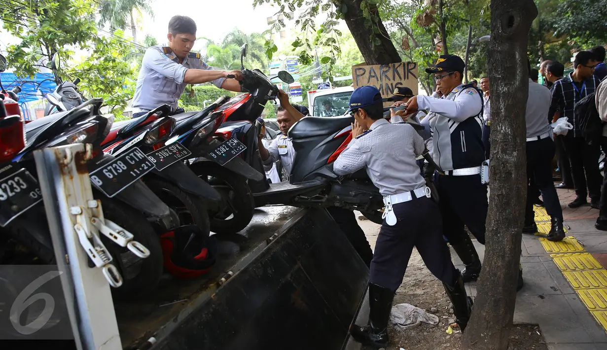 Sejumlah motor yang parkir di sepanjang trotoar kawasan Kebon Sirih, Jakarta diangkut petugas, Kamis (18/1). Puluhan motor diamankan serta digembosi dalam penertiban tersebut karena menutupi jalur pedestrian. (Liputan6.com/Immaniel Antonius)