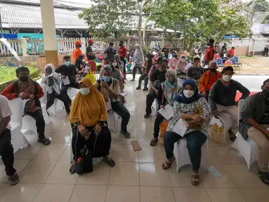 Warga menunggu saat gelaran Vaksin Covid-19 Serentak di GOR Radio Dalam, Jakarta Selatan, Selasa (8/3/2022). Vaksinasi tersebut serentak digelar di seluruh Indonesia yang diselenggarakan Kepolisian RI dengan target penyaluran vaksin sebanyak 1.114.750 dosis. (Liputan6.com/Herman Zakharia)