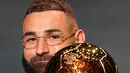 Pemain Real Madrid, Karim Benzema mengangkat trofi Ballon d'Or 2022 di Theater du Chatelet, Paris, Prancis, Senin (17/10/2022). Musim lalu, Benzema berhasil meraih empat trofi, Liga Spanyol, Liga Champions, dan Piala Super Spanyol bersama Real Madrid, serta UEFA Nations League bersama timnas Perancis. (AP Photo/Francois Mori)