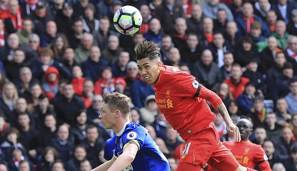 Penyerang Liverpool, Roberto Firmino, duel udara dengan bek Everton, Matthew Pennington. Laga derbi Merseyside ini berjalan seimbang, kedua klub saling bertukar serangan selama 90 menit. (AP/Peter Byrne)