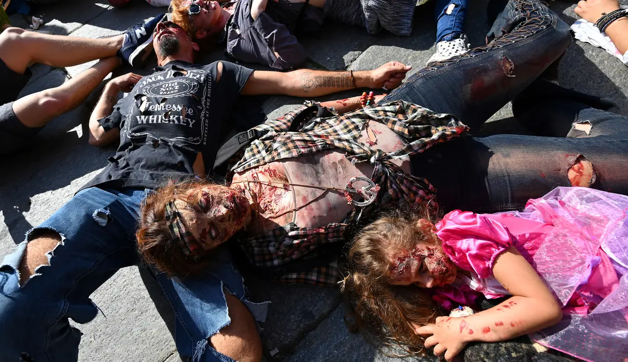 Warga memakai kostum dan berdandan menyerupai zombie saat mengambil bagian dalam acara Zombie Walk di kota Strasbourg, Prancis, 14 September 2019. Acara yang digelar dalam rangka Festival Film Fantasi Eropa ke-12 ini berlangsung dari  14 hingga 23 September. (FREDERICK FLORIN / AFP)