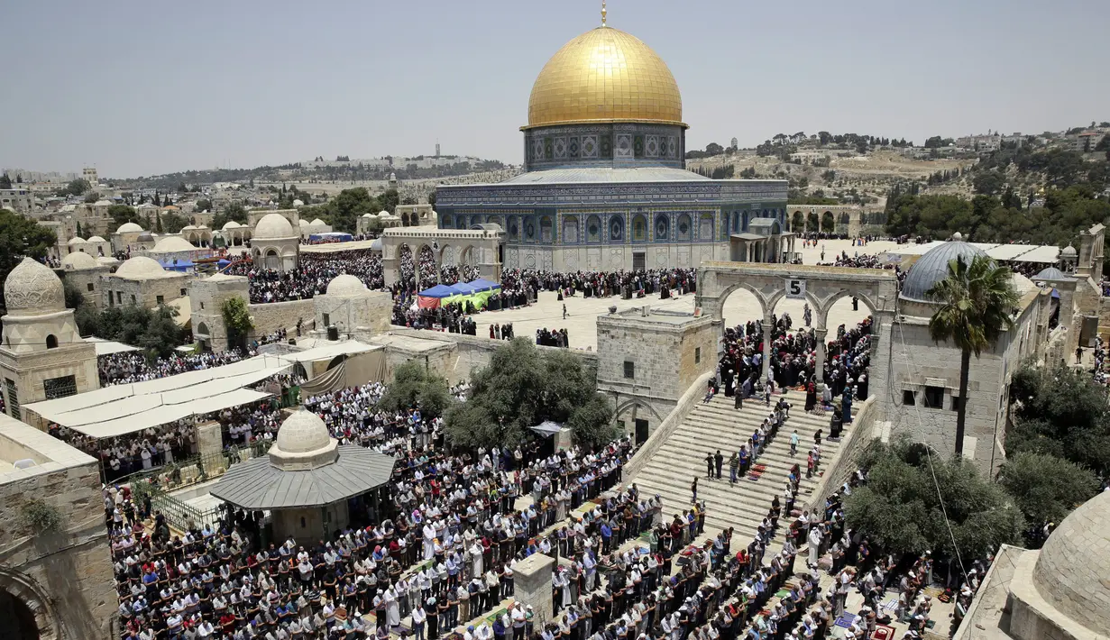 Jemaah muslim Palestina melaksakan salat di depan Dome of the Rock atau Kubah Shakhrah yang berada di tengah kompleks Masjid Al Aqsa, Yerusalem (8/6). (AP/Mahmoud Illean)