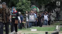 Sejumlah keluarga dan kerabat mengantarkan jenazah Vokalis grup band legendaris Koes Plus, Yon Koeswoyo untuk dimakamkan di TPU Tanah Kusir, Jakarta Selatan, Sabtu (6/1).  (Liputan6.com/Arya Manggala)