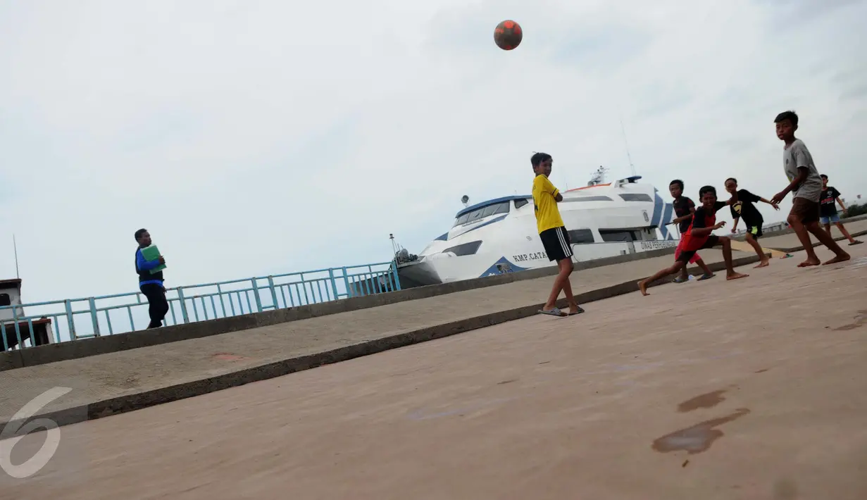 Anak-anak bermain bola di pelataran Pelabuhan Kali Adem, Muara Angke, Jakarta, Rabu (4/1). Mereka yang tinggal di pemukiman sekitar memanfaatkan Pelabuhan Kali Adem sebagai arena bermain selama mengisi masa liburan sekolah. (Liputan6.com/Gempur M Surya)