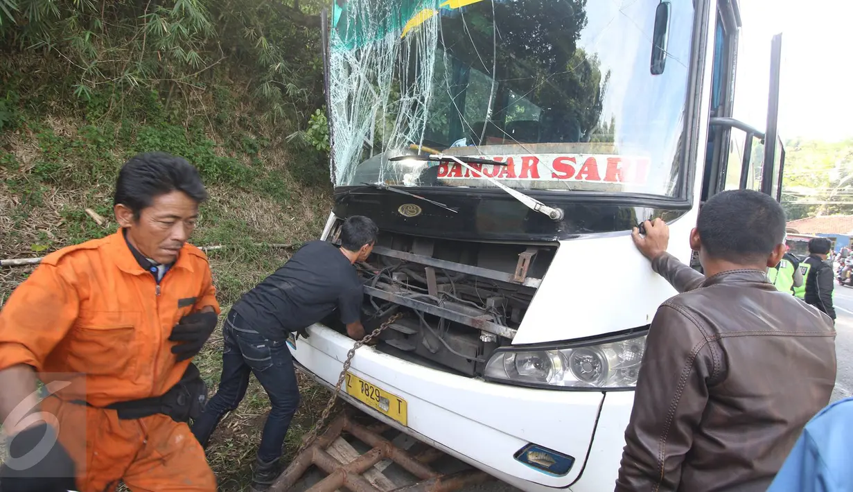 Petugas saat akan mengevakuasi bus PO Merdeka yang menabrak pohon di jalur Lingkar, Jawa Barat, Sabtu (2/7). Tidak ada korban jiwa akibat kecelakaan bus yang disebabkan rem blong tersebut. (Liputan6.com/Immanuel Antonius)