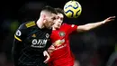 Gelandang Manchester United, Daniel James, duel udara dengan pemain Wolverhampton Wanderers, Matt Doherty, pada laga Premier League di Stadion Old Trafford, Sabtu (1/2/2020). Kedua tim bermain imbang tanpa gol. (AP/Martin Rickett)