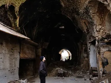 Seorang pria melihat kondisi bangunan pasar lama di kota tua Aleppo, Suriah (18/1). Perang di Aleppo telah mereda lebih dari setahun yang lalu, namun kondisi bangunan di pasar ini masih belum pulih. (AP Photo/Hassan Ammar)