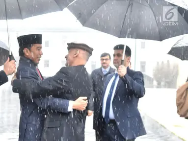 Presiden Afghanistan Ashraf Ghani merangkul Presiden RI Joko Widodo (Jokowi) saat menyambut kedatangannya di tengah hujan salju, dalam kunjungan kenegaraan di Istana Presiden Arg, Kabul, Senin (29/1). (Liputan6.com/Pool/Biro Pers Setpres)