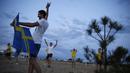 Sejumlah suporter Swedia berpesta di sekitar Pantai Sochi, Jumat (22/6/2018). Para suporter bersiap untuk menyaksikan laga Piala Dunia 2018 antara Swedia melawan Jerman. (AFP/Rebecca Blackwell)