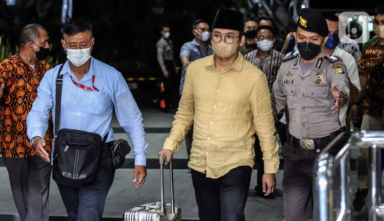 Bupati Bangkalan Abdul Latif Amin Imron membawa koper dan dikawal saat tiba di Gedung Komisi Pemberantasan Korupsi (KPK), Jakarta, Rabu (7/12/2022). KPK menangkap Bupati Bangkalan Abdul Latif Amin Imron sebagai tersangka kasus suap lelang jabatan di Pemerintahan Kabupaten Bangkalan, Jawa Timur. Total kekayaan yang dimiliki Abdul Latif sebanyak Rp 9,9 miliar. (Liputan6.com/Johan Tallo)