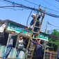 Petugas DPUPR Kota Depok menertibkan kabel udara yang semrawut di atas jalan. Pemkot menyatakan, warga bisa mengadukan masalah kabel semrawut melalui medsos DPUPR Kota Depok. (Foto: Istimewa)