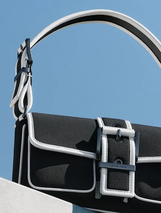 Kampanye iklan ini juga menampilkan logo Michael Kors “MK” yang diberi lapisan logam keras. Penafsiran yang berani memperkuat sisi modern dari citra baru. [Michael Kors]