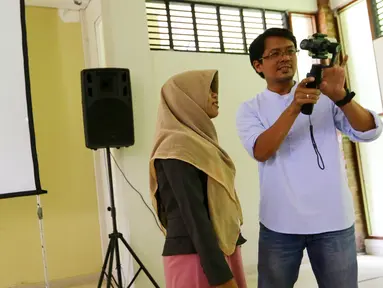 Redaktur Eksekutif Liputan6.com, Andi Muhyiddin memberikan materi Mobile Journalism (Mojo) ke salah satu peserta workshop di Universitas Negeri Semarang (UNNES), Gunung Pati, Semarang, Rabu (5/4). (Liputan6.com/Yoppy Renato)