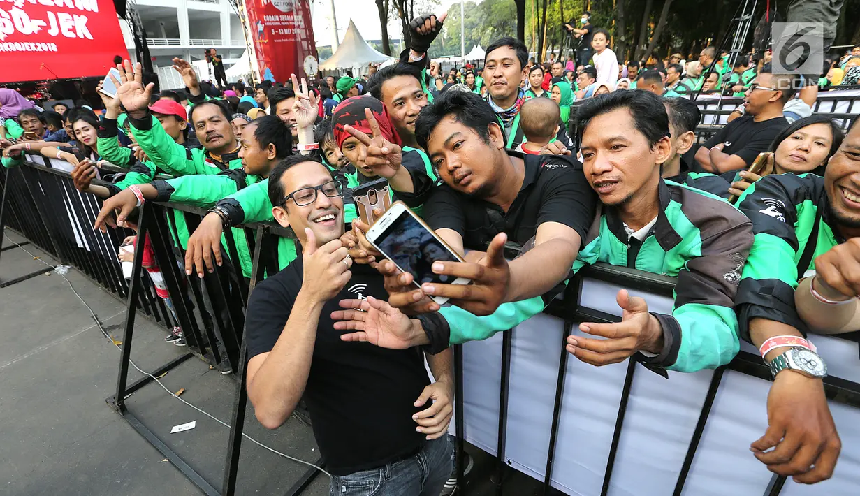 CEO GO-JEK Nadiem Makarim berswafoto bersama mitra GO-JEK saat menghadiri Pasar Malam di GO- FOOD Festival di GBK, Jakarta (11/5). Acara ini digelar sebagai bentuk apresiasi kepada mitra GO-JEK yang berprestasi. (Liputan6.com/Fery Pradolo)