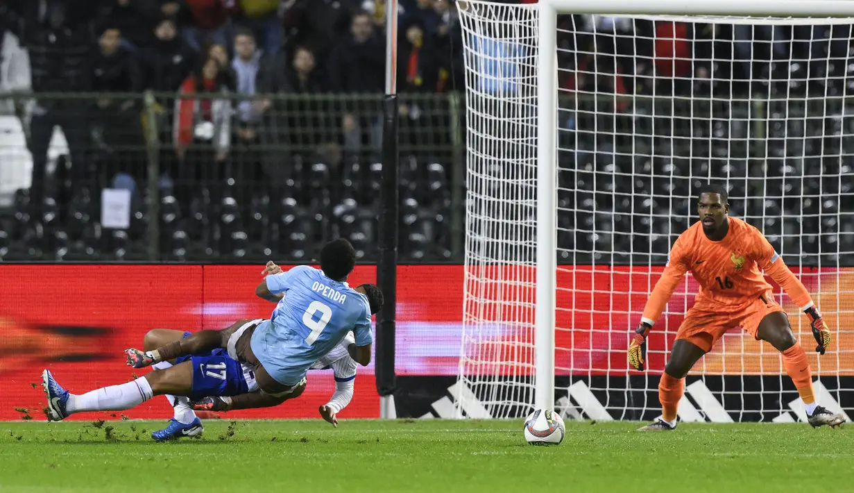 Pemain Belgia, Lois Openda (depan) dilanggar oleh pemain Prancis, William Saliba di dalam kotak penalti pada laga lanjutan UEFA Nations League A grup 2 yang berlangsung di King Baudouin stadium, Brussels, Belgia, Selasa (15/10/2024) dini hari WIB. (AFP/John Thys)