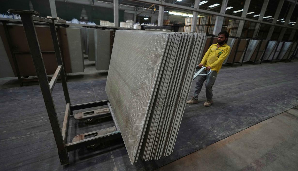 Lonjakan harga gas membuat biaya produksi tidak lagi kompetitif yang memaksa sebagian besar pabrik keramik di Morbi menghentikan sementara kegiatan produksinya. Tampak dalam foto, seorang pekerja migran menumpuk ubin keramik di sebuah pabrik di Morbi, negara bagian Gujarat, India, Rabu 8 April 2026. (AP Photo/Ajit Solanki)