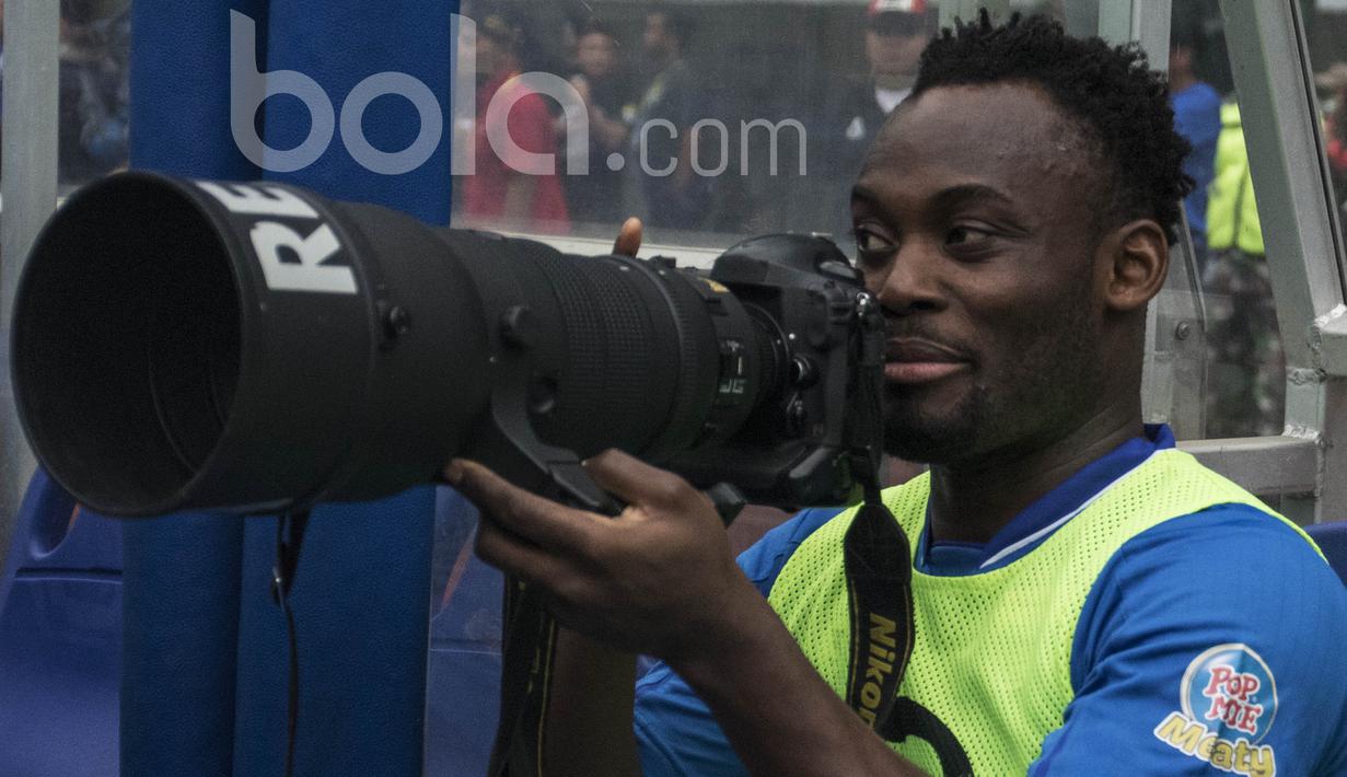Gelandang Persib Bandung, Michael Essien, mencoba kamera milik wartawan sebelum laga uji coba melawan Bali United di Stadion GBLA Bandung, Jawa Barat, Sabtu (8/4/2017). (Bola.com/Vitalis Yogi Trisna)