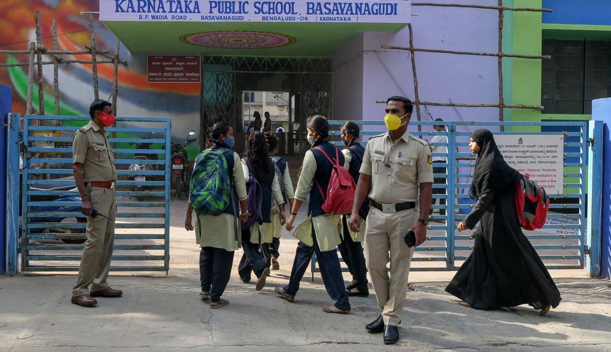Polisi berjaga-jaga ketika siswa sekolah menengah negeri dan perguruan tinggi pra-universitas untuk wanita memasuki tempat institut pendidikan di Bangalore (16/2/2022). (AFP/Manjunath Kiran)