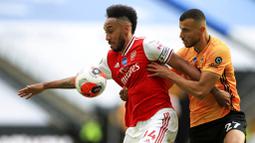 Striker Arsenal, Pierre-Emerick Aubameyang, berebut bola dengan pemain Wolverhampton Wanderers, Romain Saiss, pada laga Premier League di Stadion Molineux, Sabtu (4/6/2020). Arsenal menang dengan skor 2-0. (AP/Michael Steele)