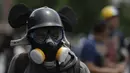 Demonstran anti-pemerintah di Venezuela mengenakan masker saat menggelar aksi di Caracas, Venezuela, Sabtu (26/5). Demonstran menuntut Maduro untuk turun dari jabatan presiden. (AP Photo)  