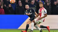 Dani Carvajal mencoba melepaskan umpan pada leg 1, 16 besar Liga Champions yang berlangsung di stadion Amsterdam Arena, Amsterdam, Kamis (14/2). Real Madrid menang 2-1 atas Ajax. (AFP/Emmanuel Dunand)