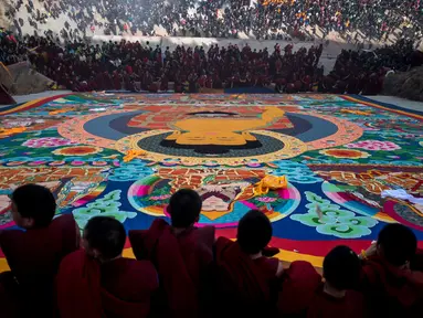 Sejumlah Biksu Tibet menggelar sebuah thangka raksasa saat upacara Monlam atau yang dikenal Festival Doa Agung Losar di Biara Rongwo, Tibet (1/3). Upacara keagamaan ini digelar untuk merayakan Tahun Baru Tibet. (AFP/Johannes Eisele)