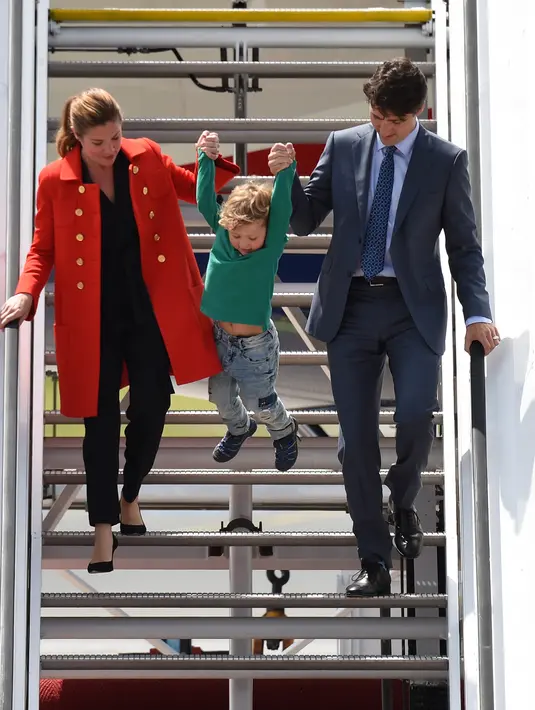 Aksi putra PM Kanada Justin Trudeau, Hadrien, saat turun dari pesawat setibanya di Hamburg, Jerman, Kamis (6/7). PM Kanada membawa istri, Sophie Gregoire-Trudeau, dan putranya, Hadrien untuk menghadiri KTT G20. (Christof STACHE / AFP)