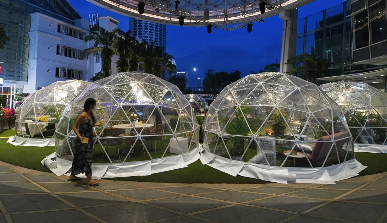 Seorang wanita berjalan melewati dining dome, instalasi tempat makan berbentuk kubah yang membantu mencegah penyebaran COVID-19, di Capitol Singapore Outdoor Plaza, Singapura, 21 Oktober 2020. (Xinhua/Then Chih Wey)
