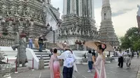 Pelancong berfoto mengenakan kostum tradisional Thailand di Wat Arun. (Liputan6.com/Melinda Indrasari)