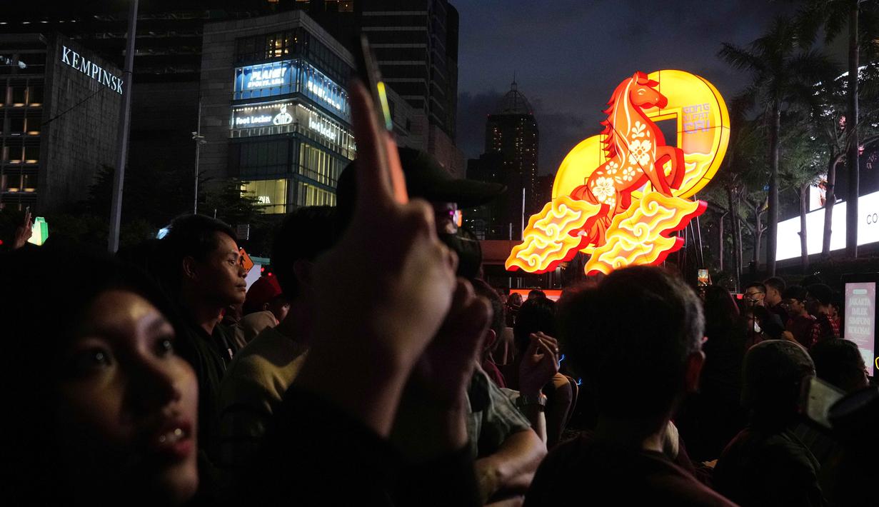 Seorang wanita menggunakan ponselnya untuk mengambil foto pertunjukan selama perayaan Tahun Baru Imlek 2577 Kongzili di kawasan Bundaran Hotel Indonesia (HI), Jakarta, Jumat 13 Februari 2026. Rangkaian Festival Imlek Jakarta 2026 dari jantung ibu kota, Bundaran Hotel Indonesia, Jakarta Pusat, resmi dibuka pada Jumat 13 Februari 2026 malam. (AP Photo/Dita Alangkara)