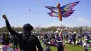 Seorang pria menerbangkan layang-layang pada Festival Blossom Kite di dekat Monumen Washington di Washington, D.C., Amerika Serikat, Sabtu (31/3). Festival ini merupakan serangkaian kegiatan menyambut bunga sakura bermekaran. (Eva HAMBACH/AFP)