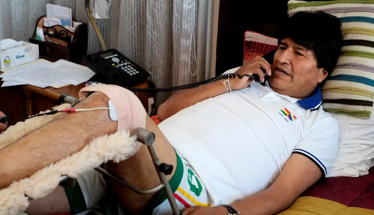 Presiden Bolivia, Evo Morales mengenakan perban pada kakinya sambil menerima telpon usai menjalani fisioterapi di kediamannya di La Paz, Bolivia, (30/6). Evo Morales memang dikenal sebagai penggila olahraga sepak bola. (REUTERS/David Mercado)