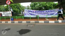 Petugas Dishub Jakarta memasang spanduk besar larangan melawan arus di putaran bawah jembatan layang Kalibata atau tepatnya setelah perlintasan kereta api Kalibata, Jakarta, Rabu (16/12/2015). (Liputan6.com/Yoppy Renato)