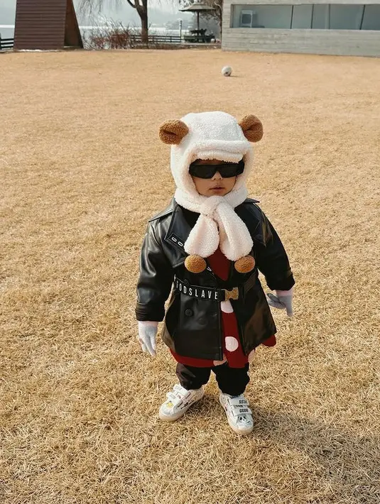 Ia juga tampil keren dengan jaket leather hitam dipadukan dress merah sebagai inner. Ia pun tampil menggemaskan dengan topi berbulu putih. [@aurelie.hermansyah]