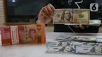 Aktivitas karyawan saat menunjukkan uang rupiah dan dolar AS di salah satu tempat penukaran mata uang asing di Jakarta, Senin (13/1/2025). (Liputan6.com/Angga Yuniar)