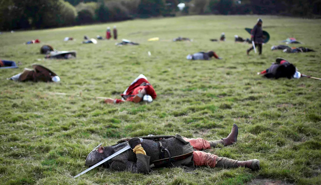 Sejumlah warga menggunakan pakaian prajurit tewas saat mereka ulang Pertempuran Hasting di Battle, Inggris, (15/10). Pertempuran Hasting terjadi di Bukit Senlac pada tanggal 14 Oktober 1066. (REUTERS/Neil Balai)