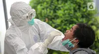 Warga menjalani tes usap PCR COVID-19 di Puskesmas Kecamatan Duren Sawit, Jakarta, Kamis (22/7/2021). Peningkatan testing dan tracing di wilayah padat penduduk diharapkan bisa mempercepat upaya memutus mata rantai penyebaran COVID-19. (Liputan6.com/Faizal Fanani)