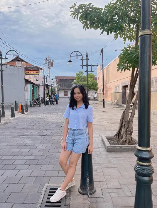 Menikmati liburan, Lyodra tampil santai dengan outfit serba biru. Mengenakan kemeja crop top stripes blue dan bawahannya hot pants jeans / (instagram/lyodraofficial)