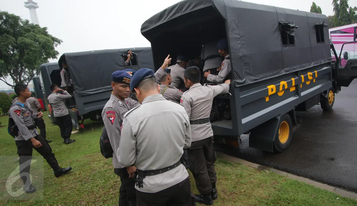 Petugas kepolisian menaiki truk pengangkut saat melakukan pengamanan di kawasan Monas, Jakarta, Selasa (18/4). Polda Metro Jaya dan Kodam Jaya mengerahkan 64.523 personel gabungan untuk mengawal Pilkada DKI 2017 putaran kedua. (Liputan6.com/Faizal Fanani)