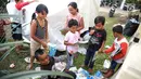 Anak-anak pengungsi Gunung Agung memegang buku di sekitar tenda Posko Pengungsi Rendang, Bali, Sabtu (2/12). Meski dalam keadaan mengungsi anak-anak tersebut tetap ceria saat bermain. (Liputan6.com/Immanuel Antonius)