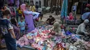 Untuk data yang dikumpulkan addalah karakteristik usaha, permodalan/investasi, kendala usaha, kinerja/daya saing, serta adopsi ekonomi digital. Tampak dalam foto, orang-orang berbelanja sepatu dan sandal di sebuah kios pakaian di salah satu ruas jalan, Surabaya, Jawa Timur, pada Minggu 19 April 2026. (JUNI KRISWANTO/AFP)