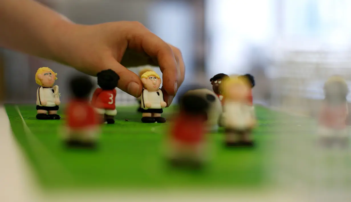 Pembuat kue meletakkan hiasan di atas kue Euro 2016 yang dibuat di sebuah tempat pembuatan kue di Munich, Jerman, Senin (20/6). Beraneka kue bertema Euro 2016 mewarnai perhelatan sepakbola Eropa. (REUTERS/Michaela Rehle)