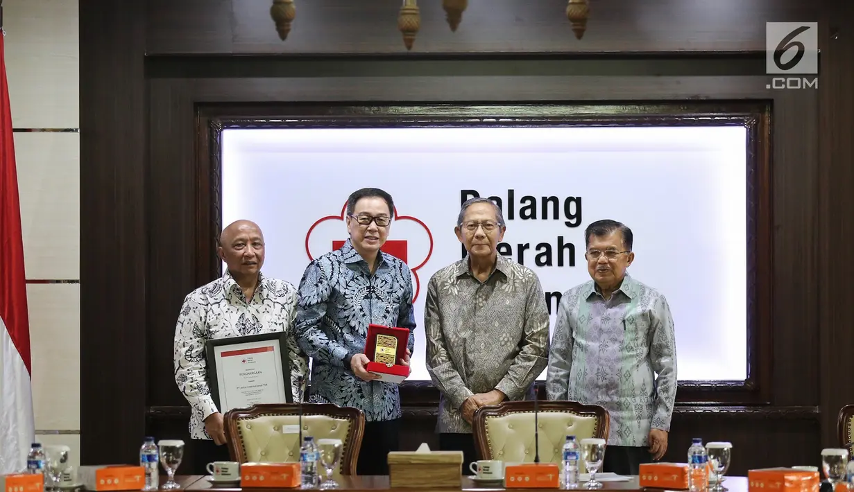 Ketum PMI Jusuf Kalla, Presdir PT Astra International Tbk Prijono Sugiarto dan Plh Ketum PMI Ginandjar Kartasasmita berfoto bersama pada acara penyerahan bantuan 10 unit truk tangki air di Kantor PMI, Jakarta, Jumat (8/2). (Liputan6.com/Fery Pradolo)