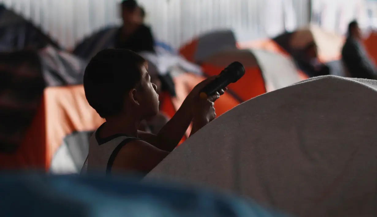 Seorang anak imigran bermain di luar tenda tempat penampungan di Tijuana, Meksiko 6 April 2019. Rombongan migran Amerika Tengah mencapai kota perbatasan antara Meksiko dan AS tersebut  untuk mencari suaka akibat kekerasan, pembunuhan dan kemiskinan yang mengancam mereka. (REUTERS/Carlos Jasso)