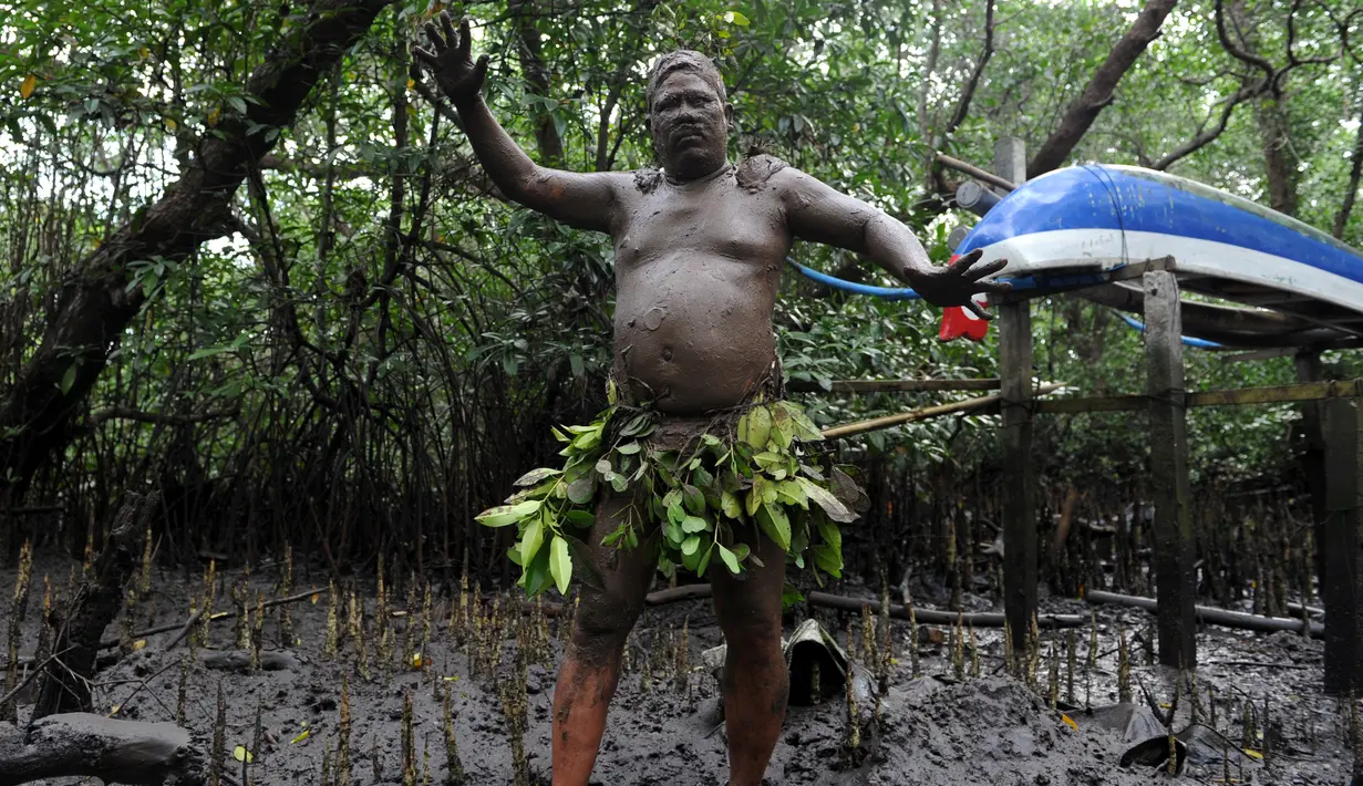 Seorang pria Bali menari dengan berlumur lumpur ditubuhnya saat mengikuti tradisi Mebuug-buugan di desa Kedonganan, Denpasar, Bali (10/3). Mebuug-buugan bertujuan untuk menetralkan sifat-sifat buruk usai hari raya Nyepi. (AFP/Sonny Tumbelaka)